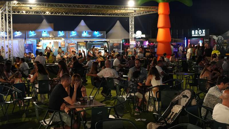 Los food trucks del Burger Fest de noche, con la zona de mesas llena